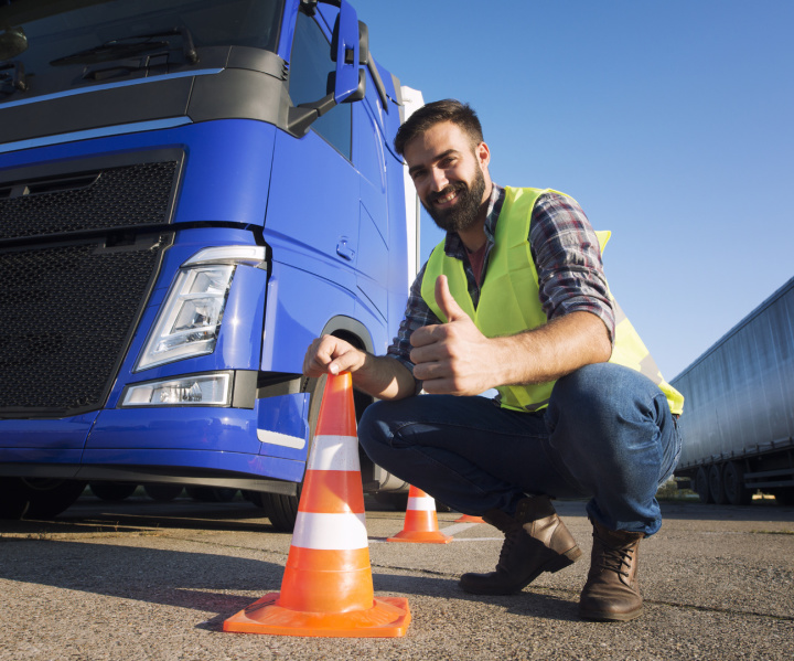 Man beside HGV lorry with a orange cone